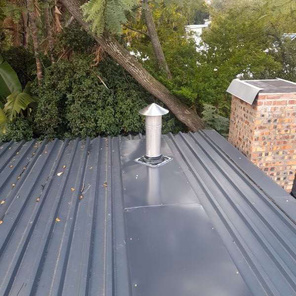 Back flashing soaker plate installation through sheet roof