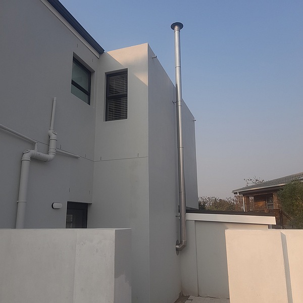 Double storey chimney up side of building past the parapet