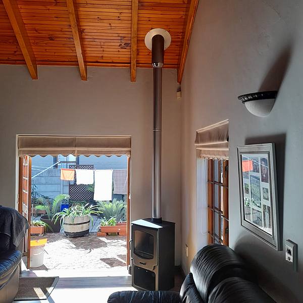wood burning stove fireplace installed through knotty pine ceiling
